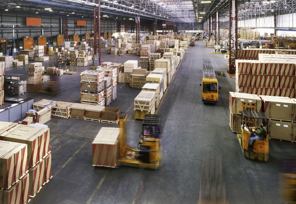 Professional movers handling heavy machinery in a warehouse
